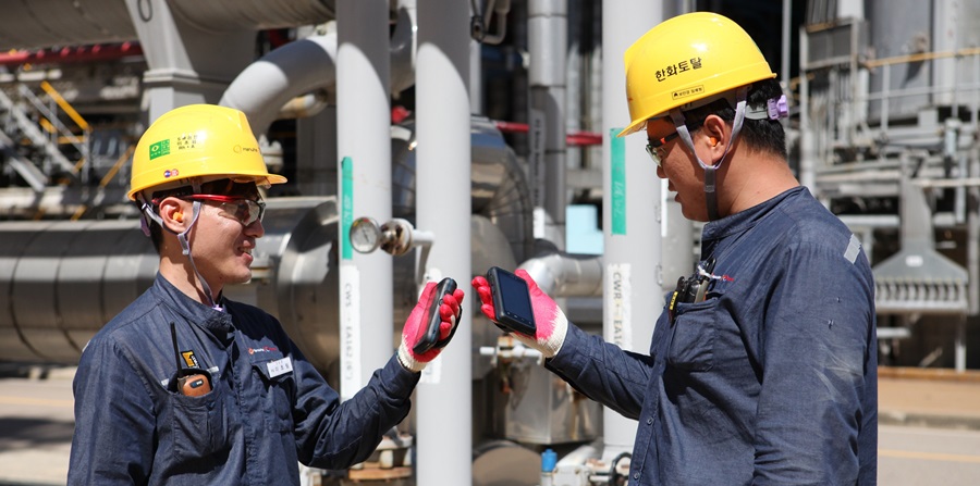 방폭 스마트폰을 들고 있는 한화토탈 직원들